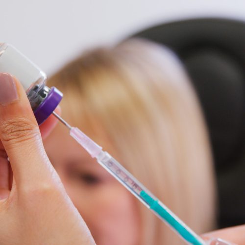 Close Up Of Beautician Or Doctor Filling Syringe Before Giving Patient Botox Injection